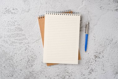 Taş zemin üzerinde dizüstü bilgisayar ve tükenmez kalem görünümü