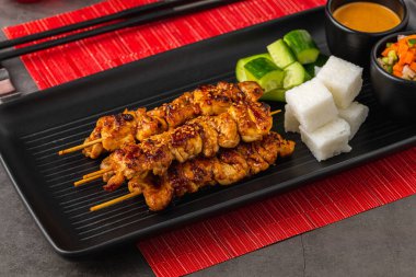 Fıstık soslu ızgara tavuk şiş, pirinç keki ve sebze.