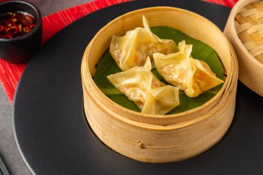 Bambu buharlı karides köftesi ve muz yaprağı, acılı soya sosuyla servis ediliyor.