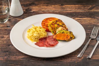 Yağda yumurta, ızgara sebze ve hindi pastırması.