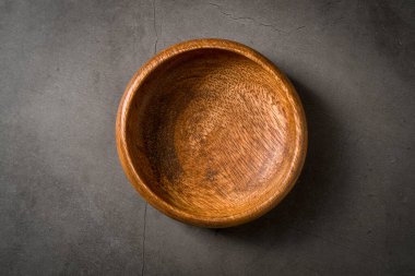 Koyu gri taş masadaki boş ahşap fındık kasesinin üst görüntüsü.