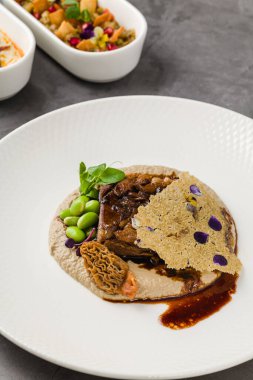 Yavaş pişirilmiş et, mantar, püre ve tül.