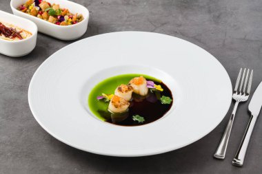 Üstünde iki çeşit sos ve havyar olan deniz tarakları.