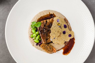 Yavaş pişirilmiş et, mantar, püre ve tül.