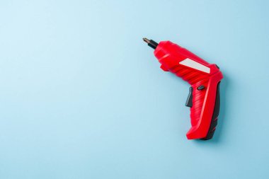 Mavi arkaplanda kırmızı kablosuz mini tornavida üst görünümü