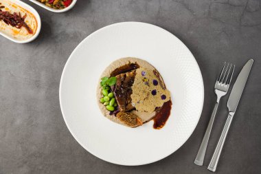 Yavaş pişirilmiş et, mantar, püre ve tül.