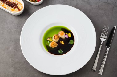 Üstünde iki çeşit sos ve havyar olan deniz tarakları.