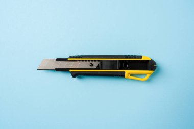 Mavi zemin üzerinde sarı ve siyah servis bıçağının üst görünümü