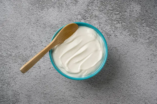 Gri taş masadaki yoğurdun en üst görüntüsü. Sağlıklı yeme kavramı