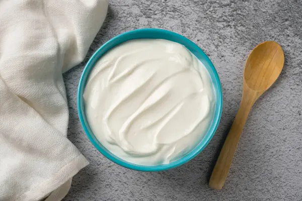 Gri taş masadaki yoğurdun en üst görüntüsü. Sağlıklı yeme kavramı