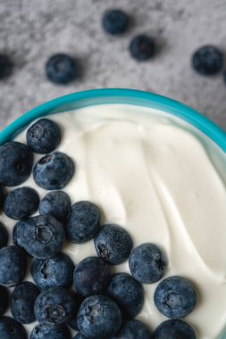Mavi kasede taze yaban mersinli yoğurt.