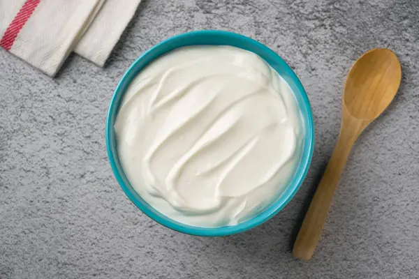 Gri taş masadaki yoğurdun en üst görüntüsü. Sağlıklı yeme kavramı