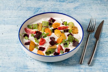 Izgara portakal, pancar, kiraz domatesli renkli yoğurt salatası ve yeşillik.