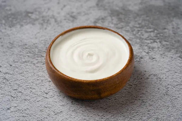 Gri taş masadaki yoğurdun en üst görüntüsü. Sağlıklı yeme kavramı