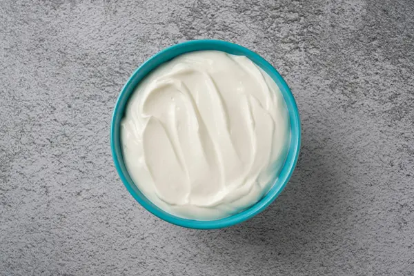 Gri taş masadaki yoğurdun en üst görüntüsü. Sağlıklı yeme kavramı