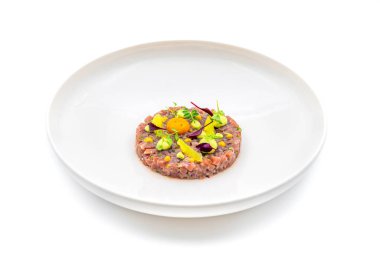 Beyaz porselen tabakta bıldırcın yumurtalı tartar.