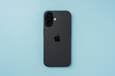 Antalya, Türkiye - 15 Haziran 2025: Mavi arkaplanda ikili arka kameraları gösteren siyah iPhone 16 'nın üst görünümü