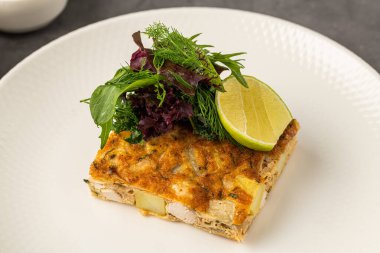 Taze yeşillik ve limonla kaplı patates ve tavuklu İspanyol tortillası.