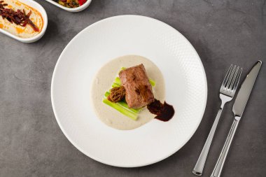 Morel mantarı ve kremalı sosla servis edilen yumuşak et madalyonu.