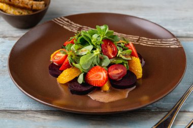 Portakal dilimleri ve yeşil yapraklı taze pancar salatası.