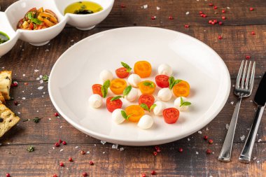 Kiraz domatesli renkli Caprese salatası, mozzarella ve taze fesleğen.
