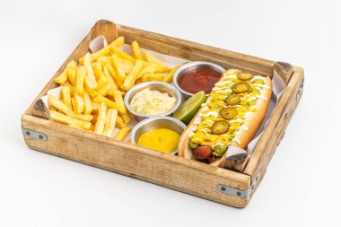 Yanında sos ve patates kızartması olan lezzetli bir sosisli sandviç.