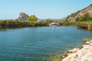 Kayalıklarda Kaunos kayalıkları manzaralı Dalyan Nehri 'ndeki tur teknesi.
