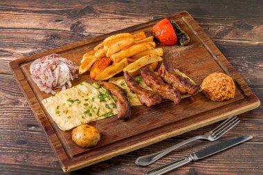 Izgara kuzu fileto ya da kızarmış patates, lavaş ekmeği ve bulgur pilavı ile servis edilen Lamb Kusleme.