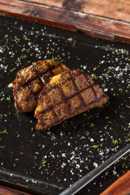 Biftek lokantasında taşın üstünde ızgara çedar peynirli köfte.