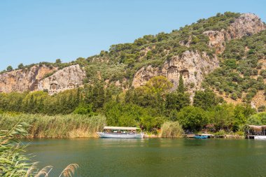 Kayalıklarda Kaunos kayalıkları manzaralı Dalyan Nehri 'ndeki tur teknesi.