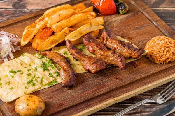 Izgara kuzu fileto ya da kızarmış patates, lavaş ekmeği ve bulgur pilavı ile servis edilen Lamb Kusleme.