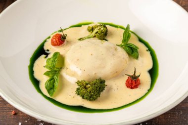 Krem soslu, brokolili ve şifalı bitkilerle servis edilen gurme makarna.