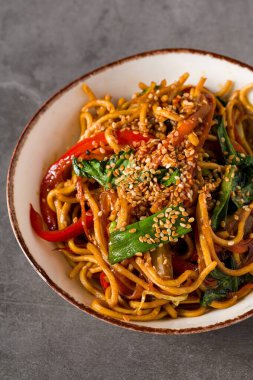 Karışık sebzeli ramen ve seramik kasede susam tohumu.