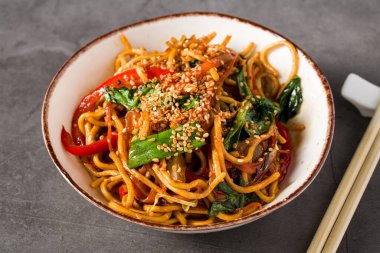 Karışık sebzeli ramen ve seramik kasede susam tohumu.