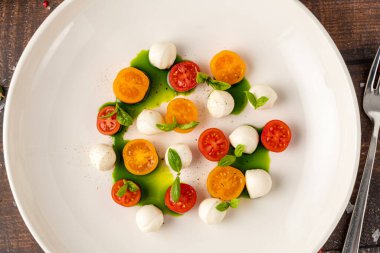 Kiraz domatesli renkli Caprese salatası, mozzarella ve taze fesleğen.