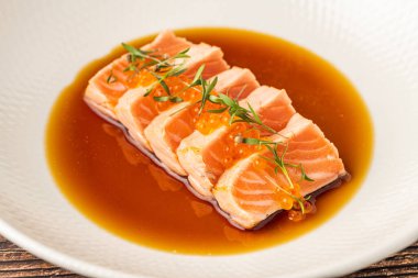 Soya soslu dilimlenmiş somon balığı ve balık yumurtası garnitürü.