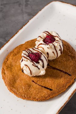 Üzerinde vanilyalı dondurma ve çikolata olan yakut kurabiyesi tatlısı.