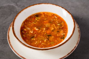 Beyaz kasede sebzeli sıcak ve ekşi Asya çorbası.