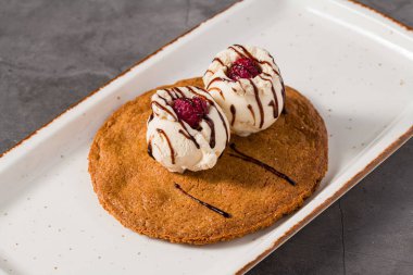 Üzerinde vanilyalı dondurma ve çikolata olan yakut kurabiyesi tatlısı.