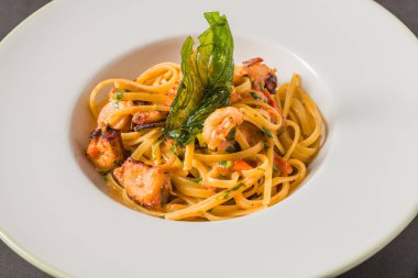 Karidesli makarna ve domates ve sarımsak soslu deniz ürünleri.