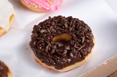 Krema ve süt tozuyla kaplı tatlı çörekler ve çikolata kaplı diğer çörekler.