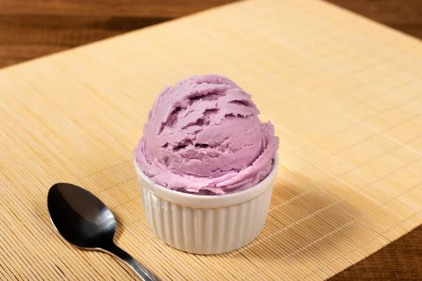 Tasty Grape-flavored purple ice cream served in white pot. Gastronomic photography, ice cream parlor and ice cream parlor.
