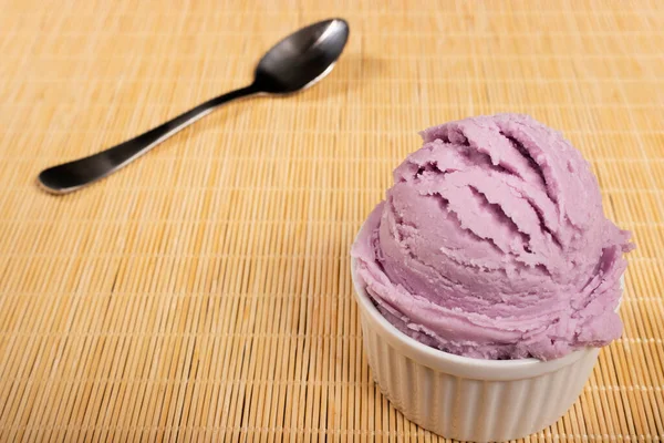 Tasty Grape-flavored purple ice cream served in white pot. Gourmet photography with free lower left space for text.