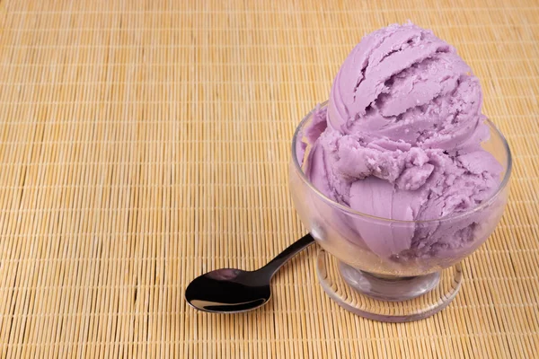 보라색 아이스크림은 숟가락이있는 투명한 그릇에서 제공됩니다 오른쪽에 정렬된 요소와 왼쪽에있는 — 스톡 사진