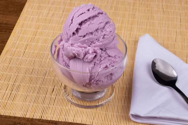 トーストグレープ風味の紫色のアイスクリームは 白ナプキンの側面にスプーン付き透明なボウルで提供しました ガストロノミック写真 アイスクリームショップ — ストック写真