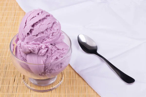 おいしいグレープ風味の紫色のアイスクリームは 側面にスプーンが付いたボウルで提供されました ホワイトナプキンは下に斜めに開いています ガストロノミック写真 — ストック写真