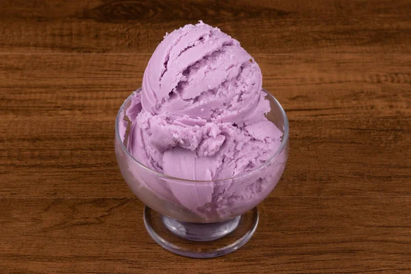 Grape-flavored purple ice cream served in a glass bowl. Close-up gastronomic photography.