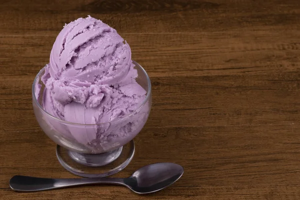 グレープ風味の紫色のアイスクリームは グラスボウルで提供されました アイスクリームの下に水平にスプーン 右のテキストのためのスペース — ストック写真