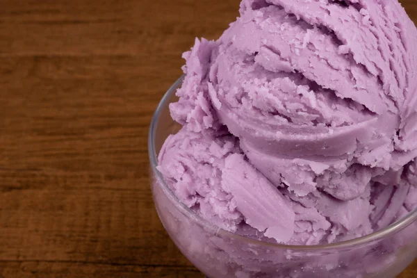 Close-up photograph of a purple grape flavored ice cream served in a glass bowl. Food on the right with space for text on the left.