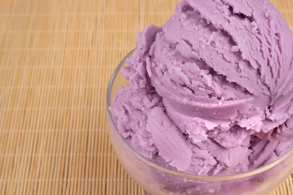 Grape-flavored purple ice cream served in a transparent bowl. Macro gastronomic photography ice cream shop.Empty space on the left.
